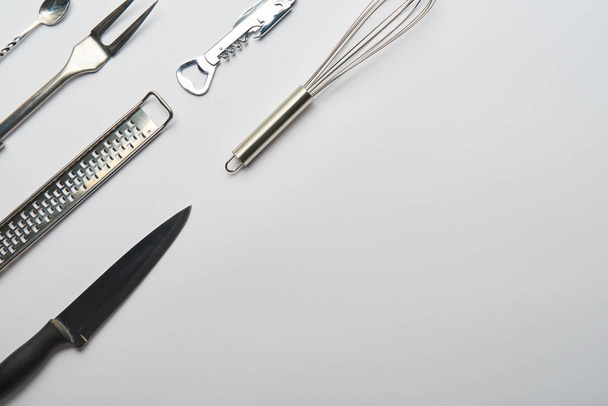 top view of metal cooking utensils on grey background with copy space - Foto, afbeelding