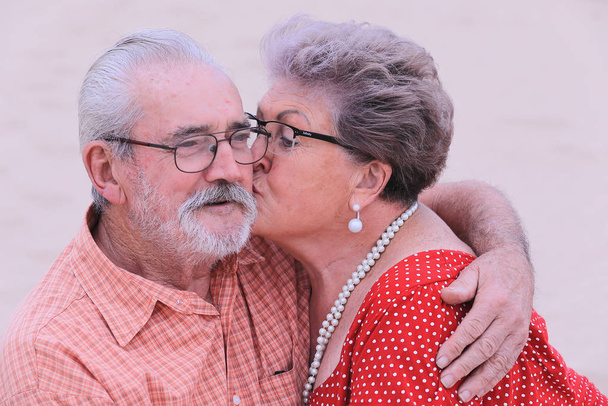 Пожилая пара наслаждается прекрасным моментом близости как раз перед закатом на пляже на южном побережье Южной Африки
. - Фото, изображение