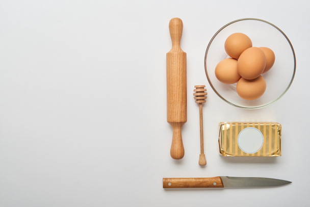 tendido plano con utensilios de cocina de madera e ingredientes de panadería cruda sobre fondo gris
  - Foto, imagen