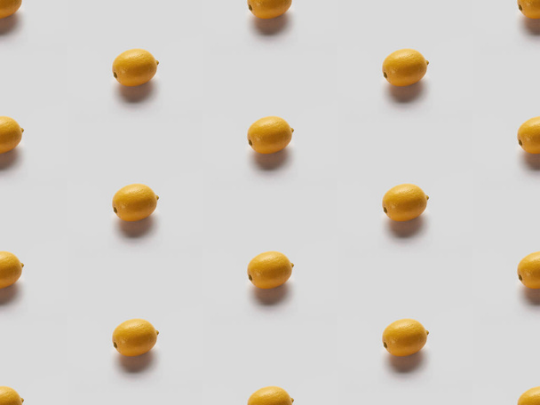 yellow bright lemons on grey background, seamless pattern - 写真・画像