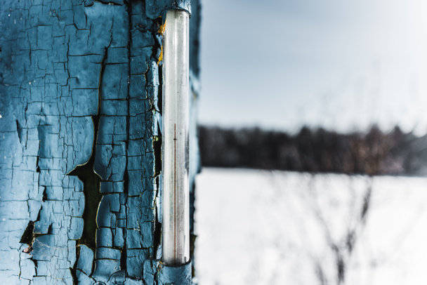 Selektiver Fokus des Thermometers im verwitterten alten blauen Brett im Winter - Foto, Bild