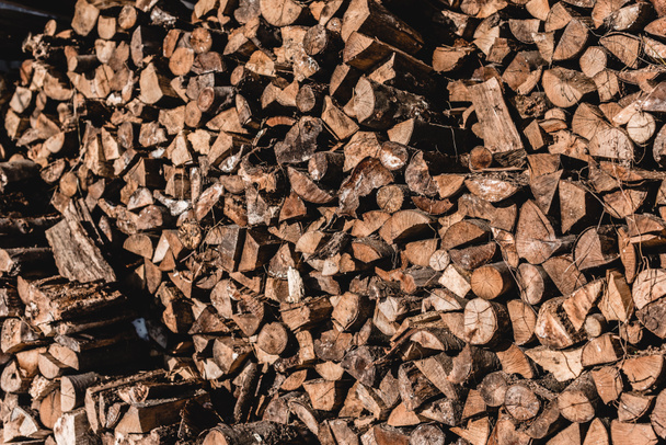 stapel bruin gesneden brandhout op zonnige dag  - Foto, afbeelding
