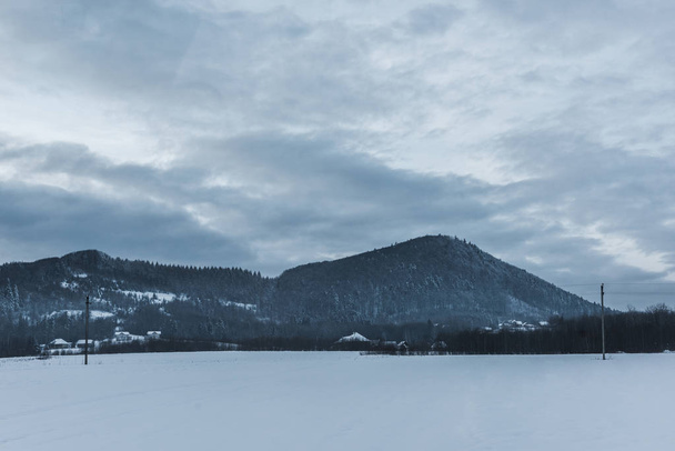 vista panorámica de las montañas de carpatos nevados y el cielo nublado en invierno
  - Foto, imagen