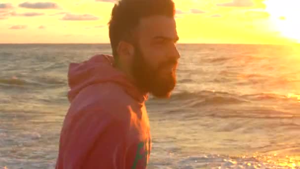 De man met de baard bewondert de zee bij zonsopgang - Video