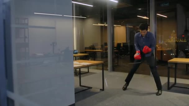 Angry energy in work. Businessman ready to fight for job. He waving sport red boxing gloves in camera POV. Wide shot in slow motion. - Footage, Video