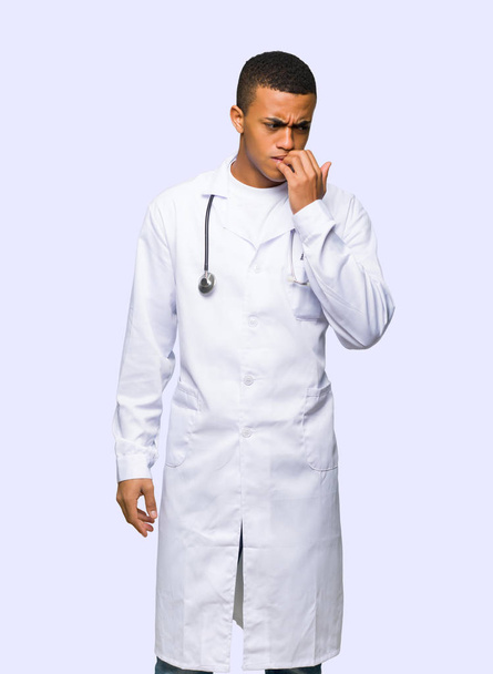 Young afro american man doctor having doubts on isolated background - Фото, изображение