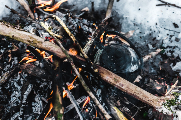 κάτοψη του βραστήρα με καπνό στη φωτιά στο δάσος του χειμώνα - Φωτογραφία, εικόνα