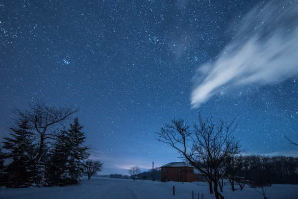 tähtikirkas tumma taivas ja talo Karpaattien vuorilla yöllä talvella
 - Valokuva, kuva