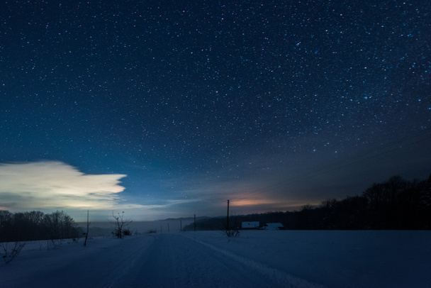 starry dark sky and road in carpathian mountains at night in winter - Photo, Image