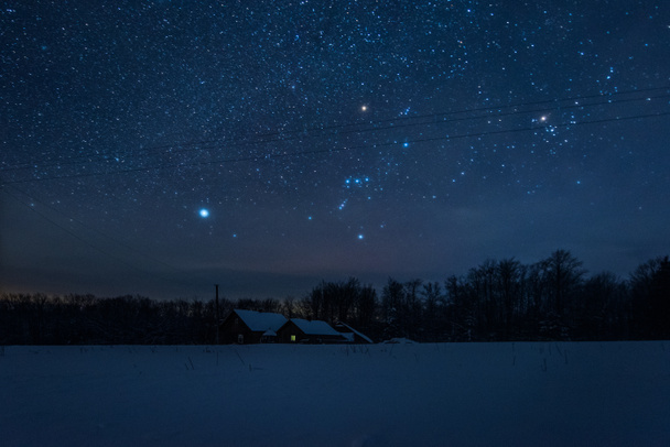 starry dark sky and house in carpathian mountains at night in winter - Foto, imagen