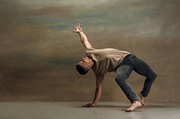 The young man dancing on gray - Foto, Bild