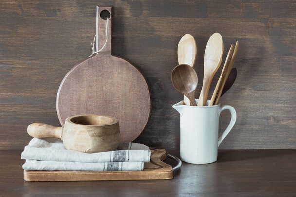 Crockery, porcelain, white utensils and other different stuff on wooden countertop. Kitchen still life as background for design. Copy space. - Foto, afbeelding