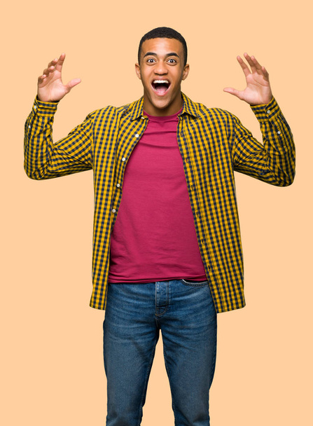 Young afro american man with surprise and shocked facial expression on isolated background - Photo, image
