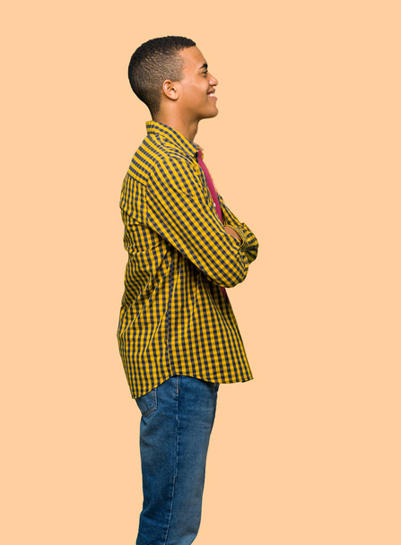 Young afro american man in lateral position on isolated background - 写真・画像