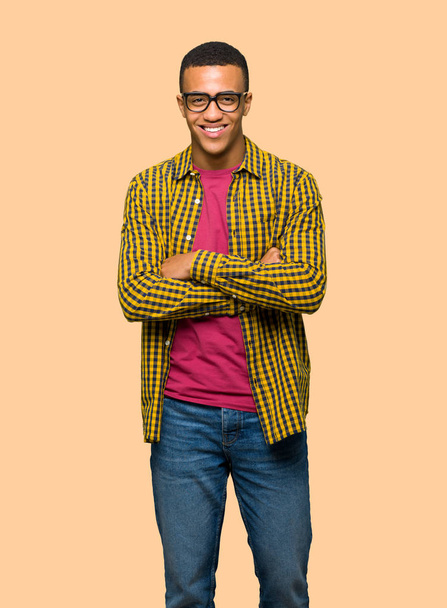Young afro american man with glasses and happy on isolated background - 写真・画像