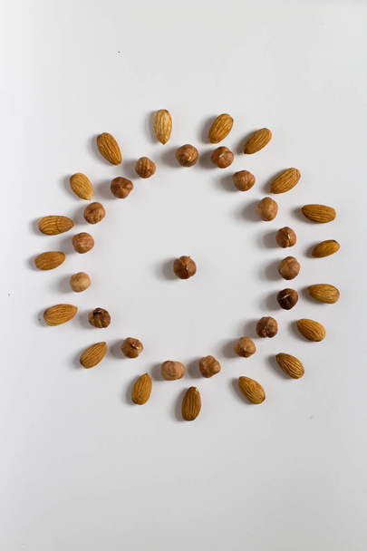 handful of nuts on a white background, almonds and hazelnuts - Photo, image