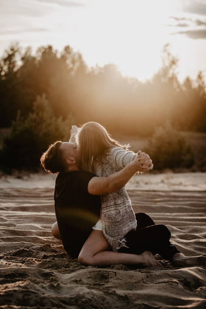 Nuori, onnellinen pari suutelee rannalla
  - Valokuva, kuva