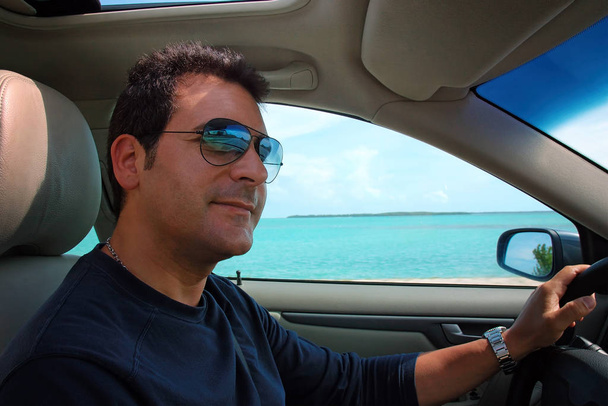 Man conduit la voiture le long de l'Overseas Highway, la route de Miami à Key West, la pointe la plus méridionale des États-Unis. Par une journée ensoleillée d'été, en arrière-plan l'océan bleu
. - Photo, image