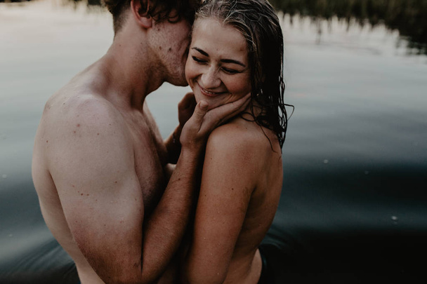 Jovem casal abraçando no lago
 - Foto, Imagem