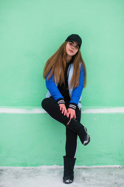 Portrait of teen girl near green wall in winter - Foto, immagini