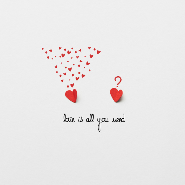 Widok z góry dwa czerwone papieru wyciąć serca na białym tle z "Miłość to wszystko czego potrzebujesz" napis  - Zdjęcie, obraz