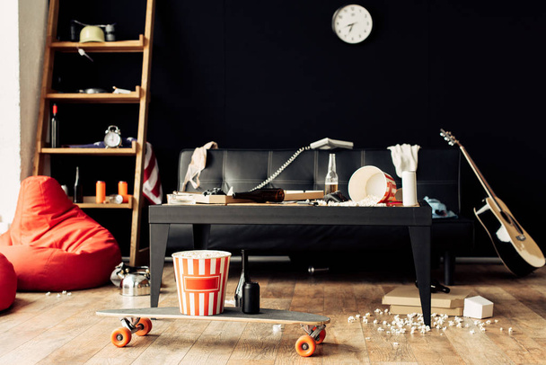 skateboard with food and drinks in messy living room - Foto, imagen