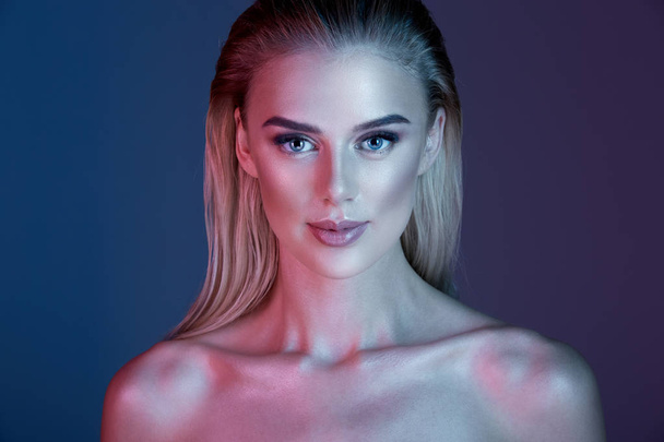 Pretty girl with make up and blonde hair posing with at dark blue background - Foto, Bild