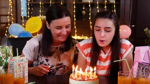 Mutlu genç kız ve annesi ile doğum günü pastası yıldönümü partisinde. Doğum günü pastası mum aydınlatma. İnsanlar kutluyor doğum günü kavramı. Yavaş hareket 4k el hareketi - Video, Çekim