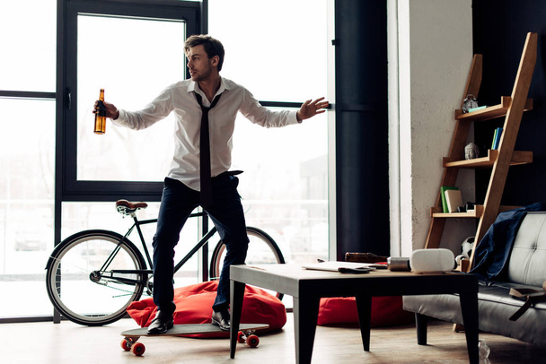 άνδρας ιππασία skateboard και να κατέχουν ποτό μετά από πάρτι στο σπίτι - Φωτογραφία, εικόνα