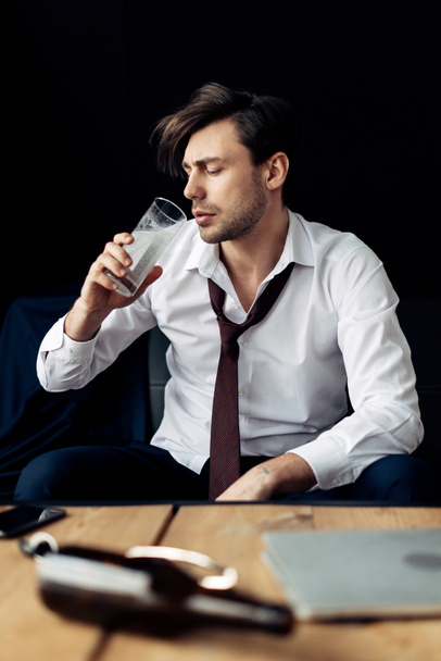 schöner betrunkener Mann im Anzug trinkt nach Party Wasser - Foto, Bild