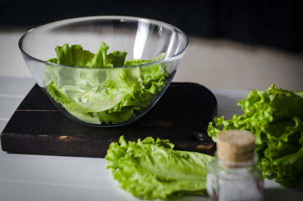 Man is preparing green salad of romaine lettuce. Healthy food concept - Zdjęcie, obraz