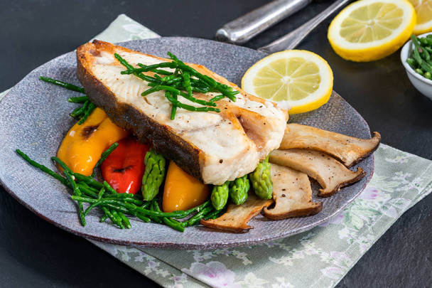 Grilled halibut steak with vegetables - sweet mini peppers, courgette, asparagus and oyster mushrooms, garnished with samphire - Foto, Imagen