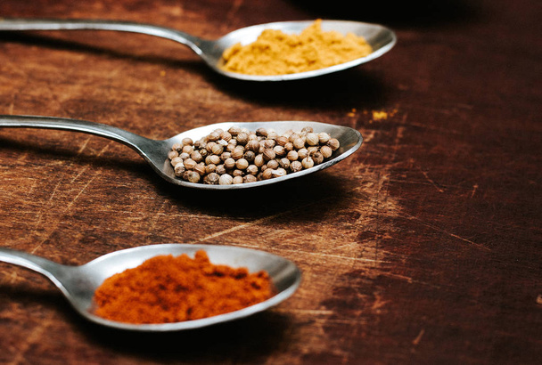 Colourful various herbs and spices for cooking on dark background.The herbs and spices on a wooden background. - Photo, image