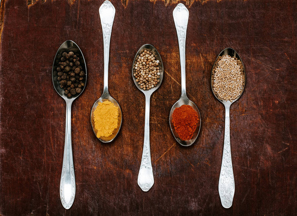 Colourful various herbs and spices for cooking on dark background.The herbs and spices on a wooden background. - Foto, Imagen