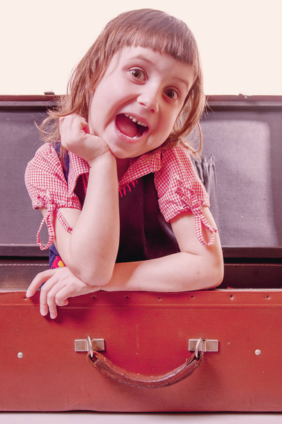 Happy cute little child girl sitting in suitcase and waiting for travel and adventure. - Valokuva, kuva