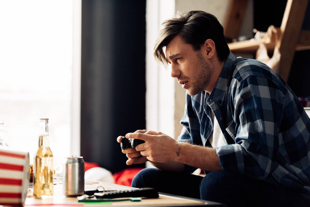 ospalý muž hraje videohry doma  - Fotografie, Obrázek