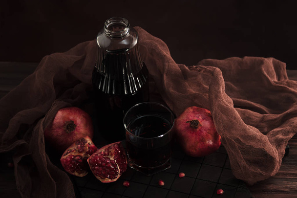 Pomegranate juice in a bottle and a glass of fruit - Foto, afbeelding