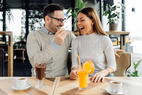 Hombre alimentando a su novia con chocolate caliente
 - Foto, Imagen