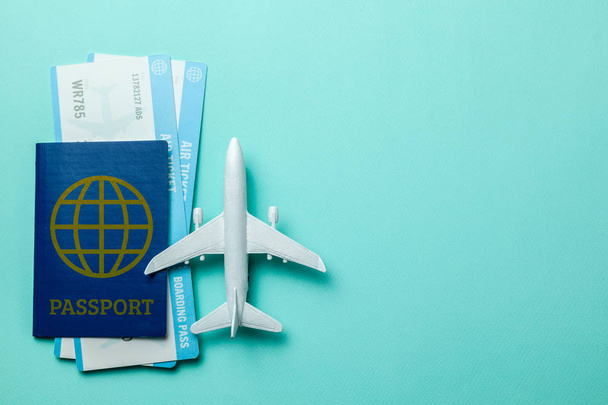 Billetes para avión y pasaporte con modelo de avión de pasajeros sobre fondo verde menta. Copiar espacio para texto
 - Foto, imagen