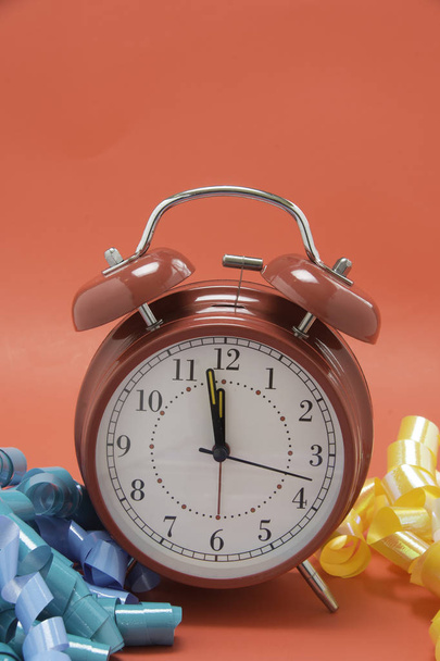 Red Alarm clock and ribbon for holiday occasions. - Φωτογραφία, εικόνα