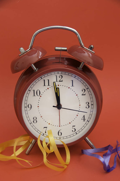 Red Alarm clock and ribbon for holiday occasions. - Fotó, kép