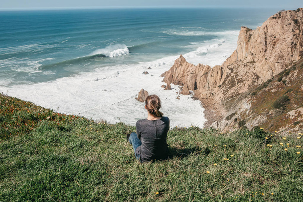 孤独の崖の上部に女の子は、大西洋の美しい景色を賞賛します。 - 写真・画像