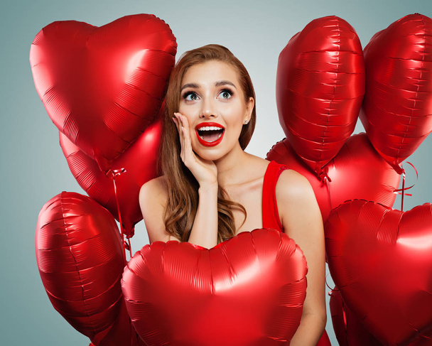 Surprised girl with red balloons, srprise, gifts and Valentine's day holiday party celebration background - Photo, Image