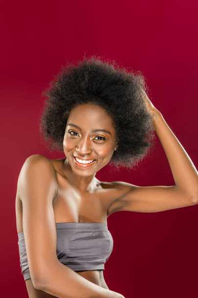 Mulher alegre positivo tocando seu cabelo encaracolado
 - Foto, Imagem