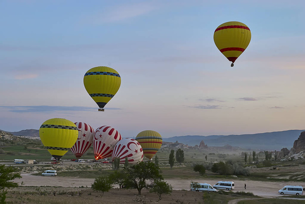 Kappadokie, Turecko - 02 květen 2013: Barevné horkovzdušné balóny létání nad údolím v Cappadocia. Horkovzdušné balóny jsou tradiční turistické atrakce v Kappadokie. - Fotografie, Obrázek