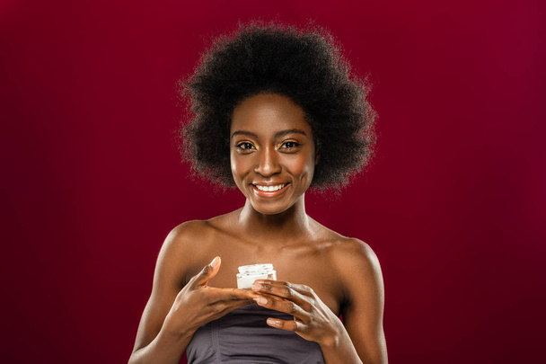 Delighted positive woman holding a bottle with cream - Photo, image