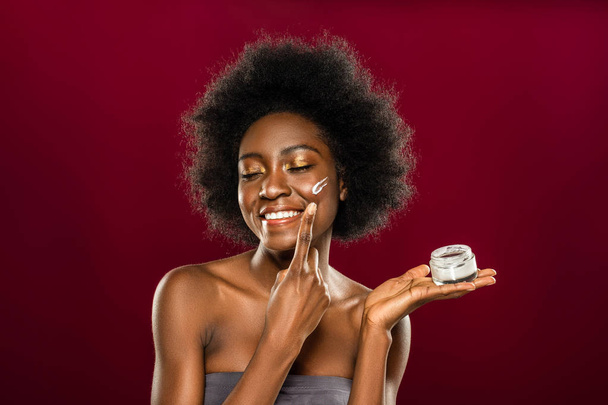 Delighted Afro American woman caring about her skin - Фото, изображение