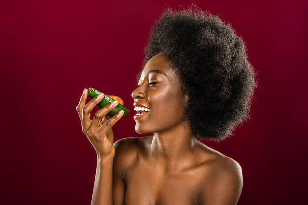 Delighted cheerful woman looking at the avocado - Valokuva, kuva