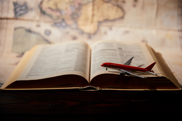 Selective focus of toy plane, book and map on table - Photo, Image