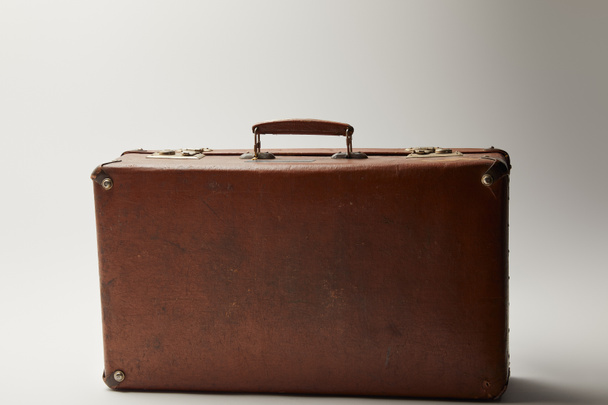 vintage leather brown suitcase on grey background  - 写真・画像